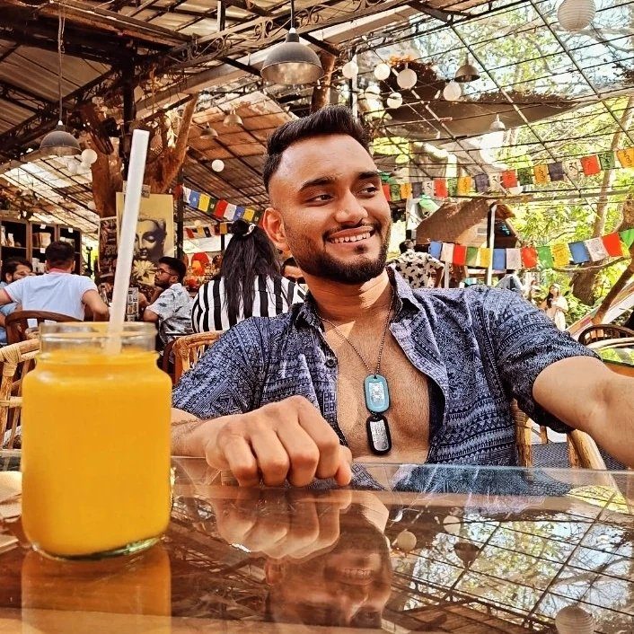 Nishant, founder of Elite Social Skills, smiling at a café table